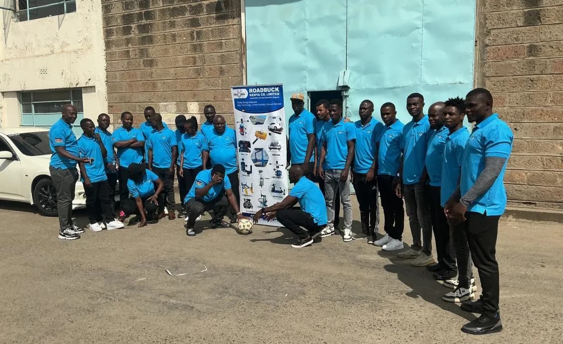 RoadBuck Kenya colleagues together beside the company equipment display